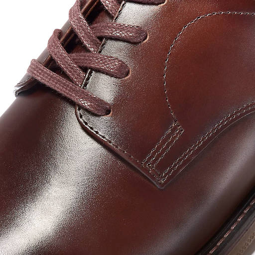 Closeup of a brown Oxford shoe laced with flat laces.
