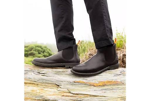 Image shows someone wearing black Timberland boots in the summer.
