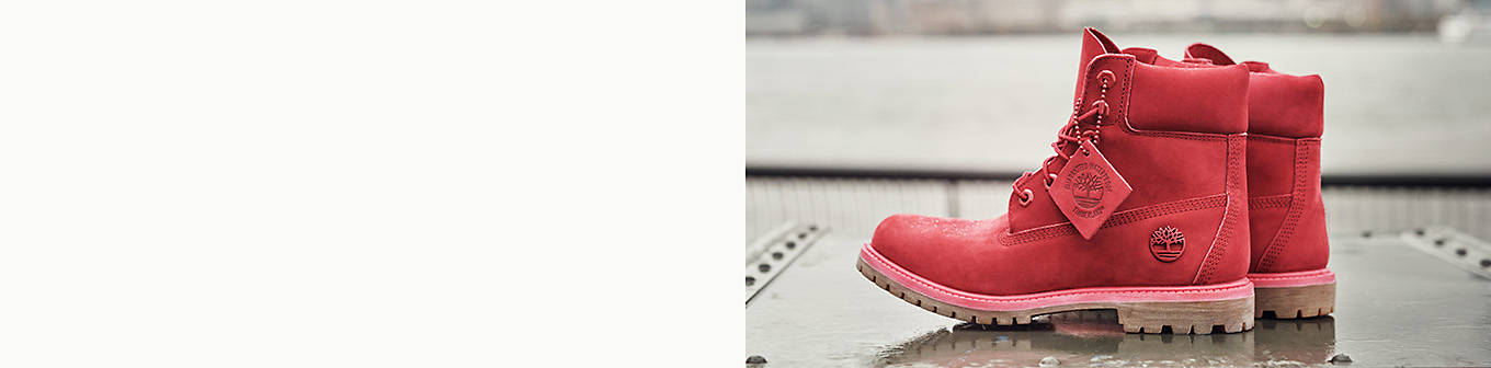 Image of Women's Ruby Red 6-Inch Premium Waterproof Boots on top of a wet sheet of metal which is facing a river in the city.