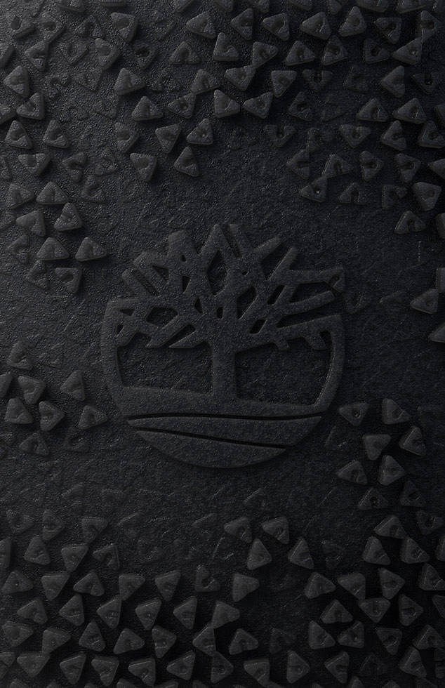 Image of black textured rubber with Timberland tree logo surrounded by triangles.