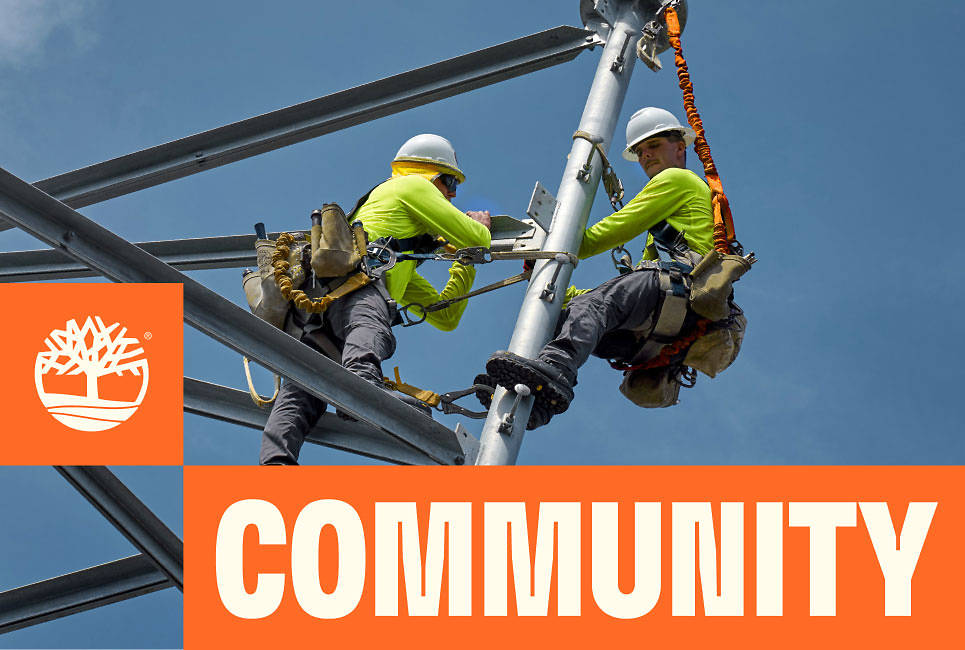 Two workers in safety harnesses and Timberland Pro boots and clothing work on a scaffold, with the headline 'COMMUNITY'