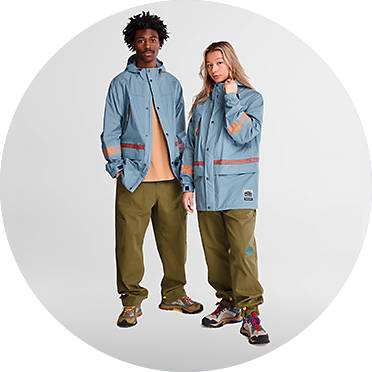 Man and a woman both wearing light blue jackets and olive green pants by Timberland X Bee Line Drop 2