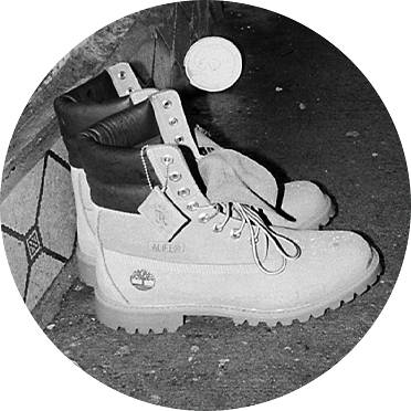Black and white photo of yellow Timberland X Alife boots on city street