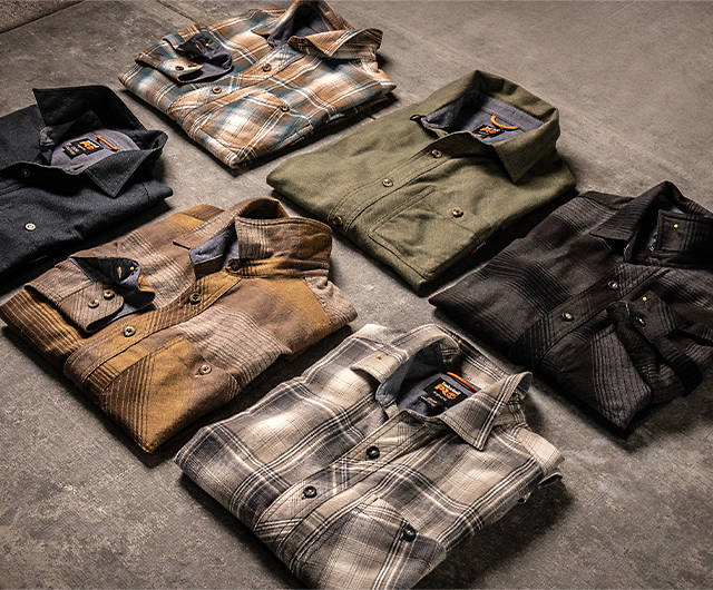 flannel shirts in many colors folded on a table