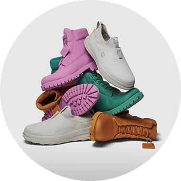 Piled stack of various colored footwear for men and women from Pangaia X Timberland