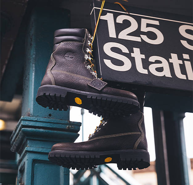 Pair of Timberland Super Boots hanging by the laces on a 125th Street New York City subway sign