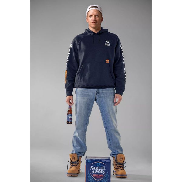Man wearing Men's Sam Adams x Timberland PRO Beerproof Hoodie and Men's Sam Adams x Timberland PRO Direct Attach Beerproof Boots while holding a Samuel Adam's Lager which he grabbed from this Samuel Adam's Lager 12-Pack. Swipe right to get to the next product in the image carousel.