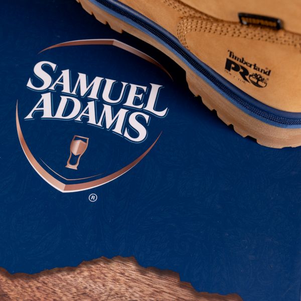 Overhead view of the Samuel Adam's logo next to a close-up of the rear of the Men's Sam Adams x Timberland PRO Direct Attach Beerproof Boots. Swipe right to get to the next product in the image carousel.